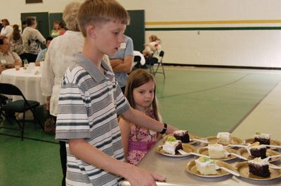 Sunday Party at OLS School
Cake: Riley Hughes assists with cake serving.  Julia Higham helps.
