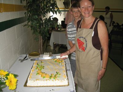 Sunday Party at OLS School
Cake:  Ann Higham Hughes prepares to serve cake with Riley ready to help.
